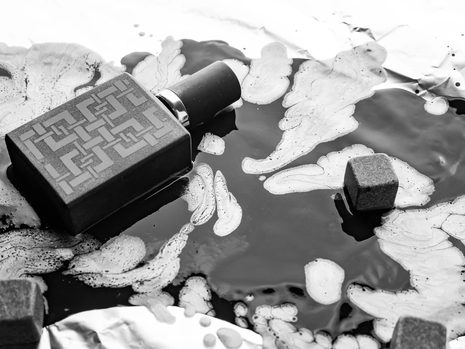 Editorial perfume bottle composition on a dark textured surface.