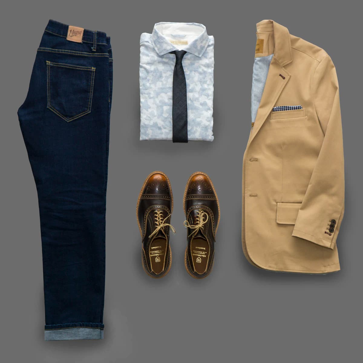 Dark denim jeans paired with brown leather shoes, close-up.